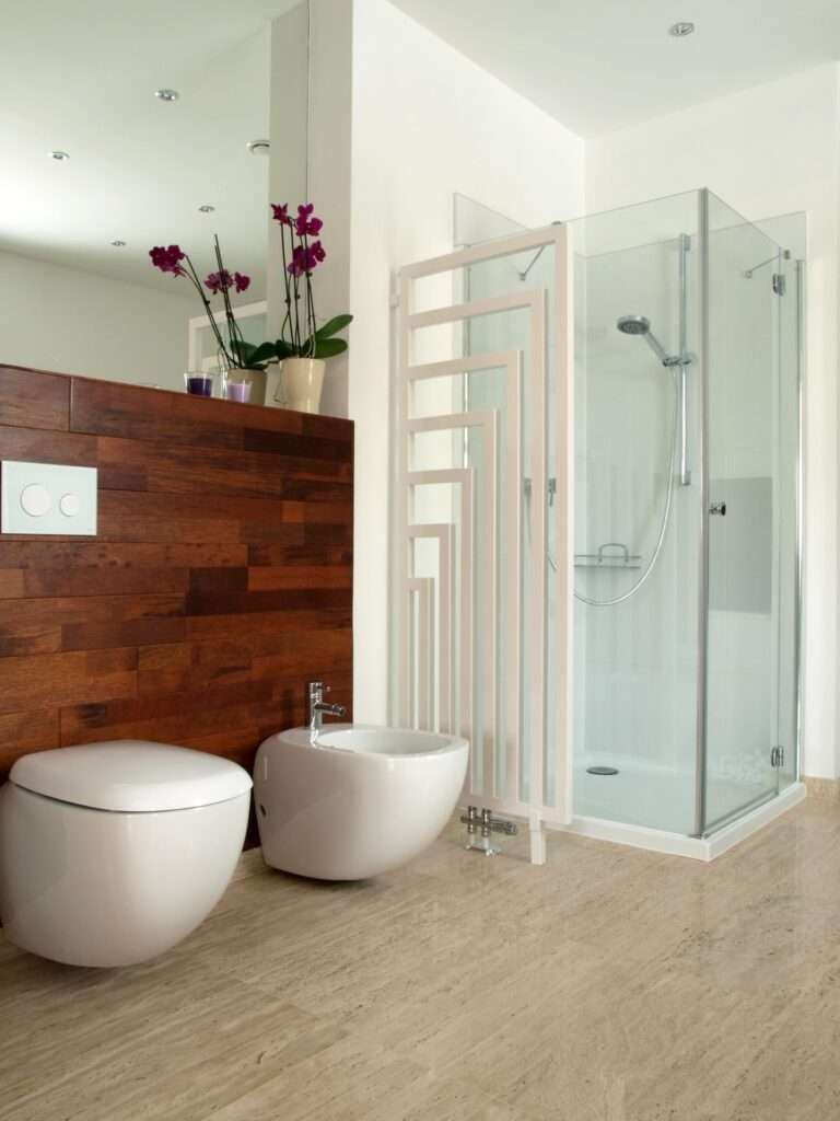 Stijlvolle badkamer met houtlook tegels op de muur, modern sanitair en inloopdouche met glazen wand.