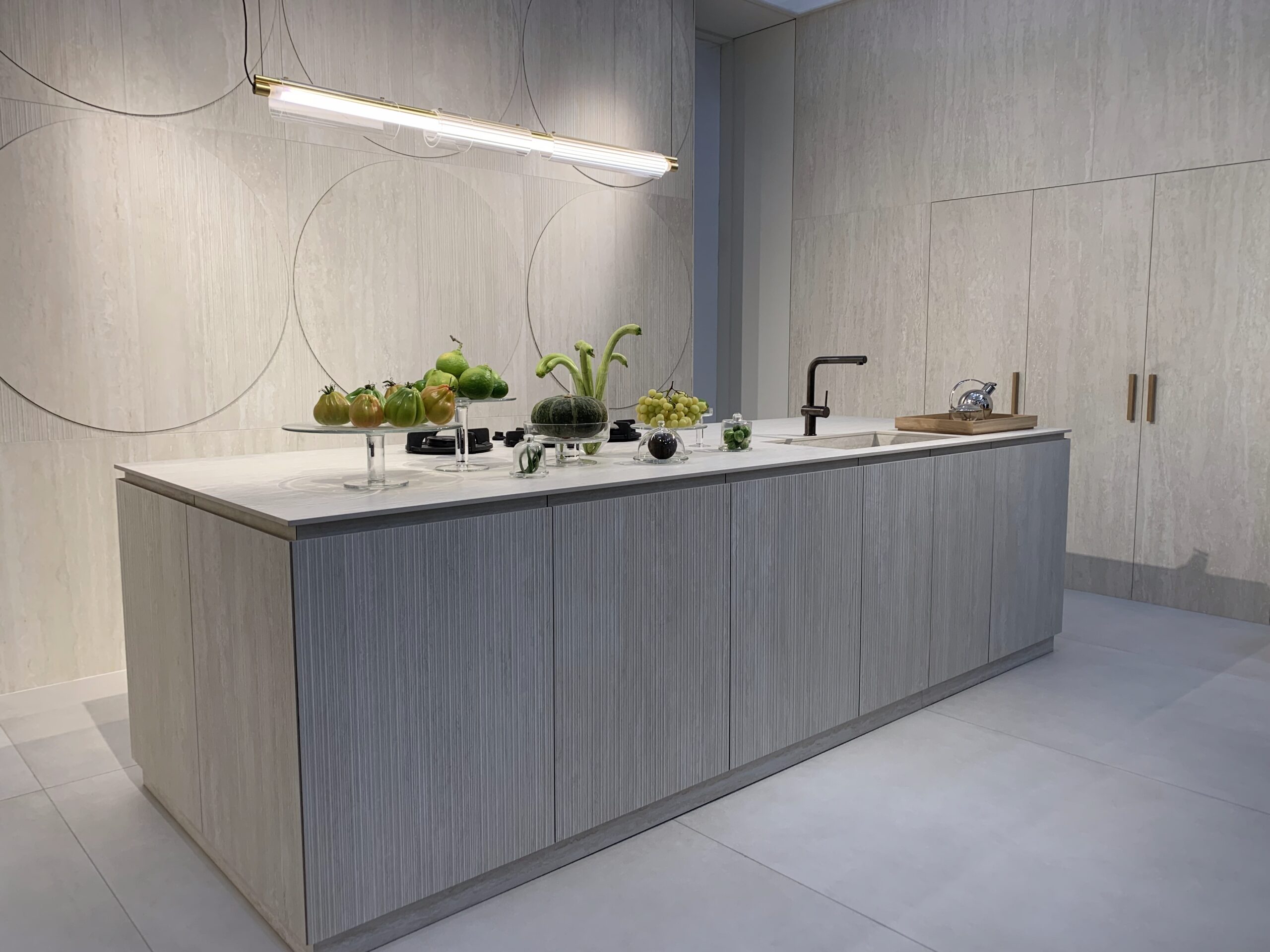 Luxe moderne keuken met lichte keramische tegels op vloer en wanden, minimalistisch design en kookeiland – inspiratie voor stijlvolle en onderhoudsvriendelijke keukentegels